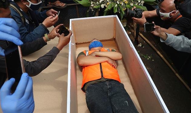 В Индонезии нарушителей масочного режима кладут в гроб